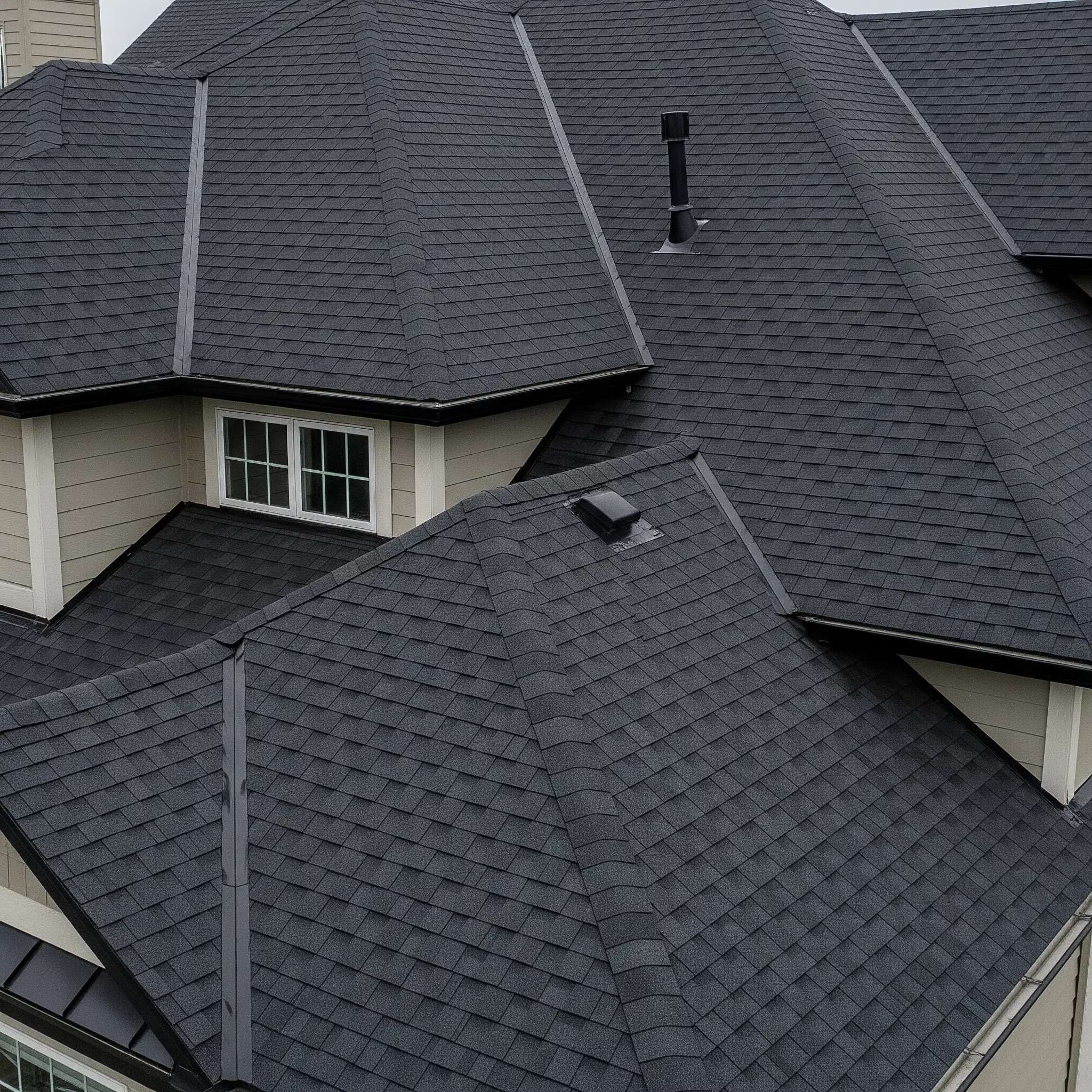 Aerial view of a newly installed dark shingle roof